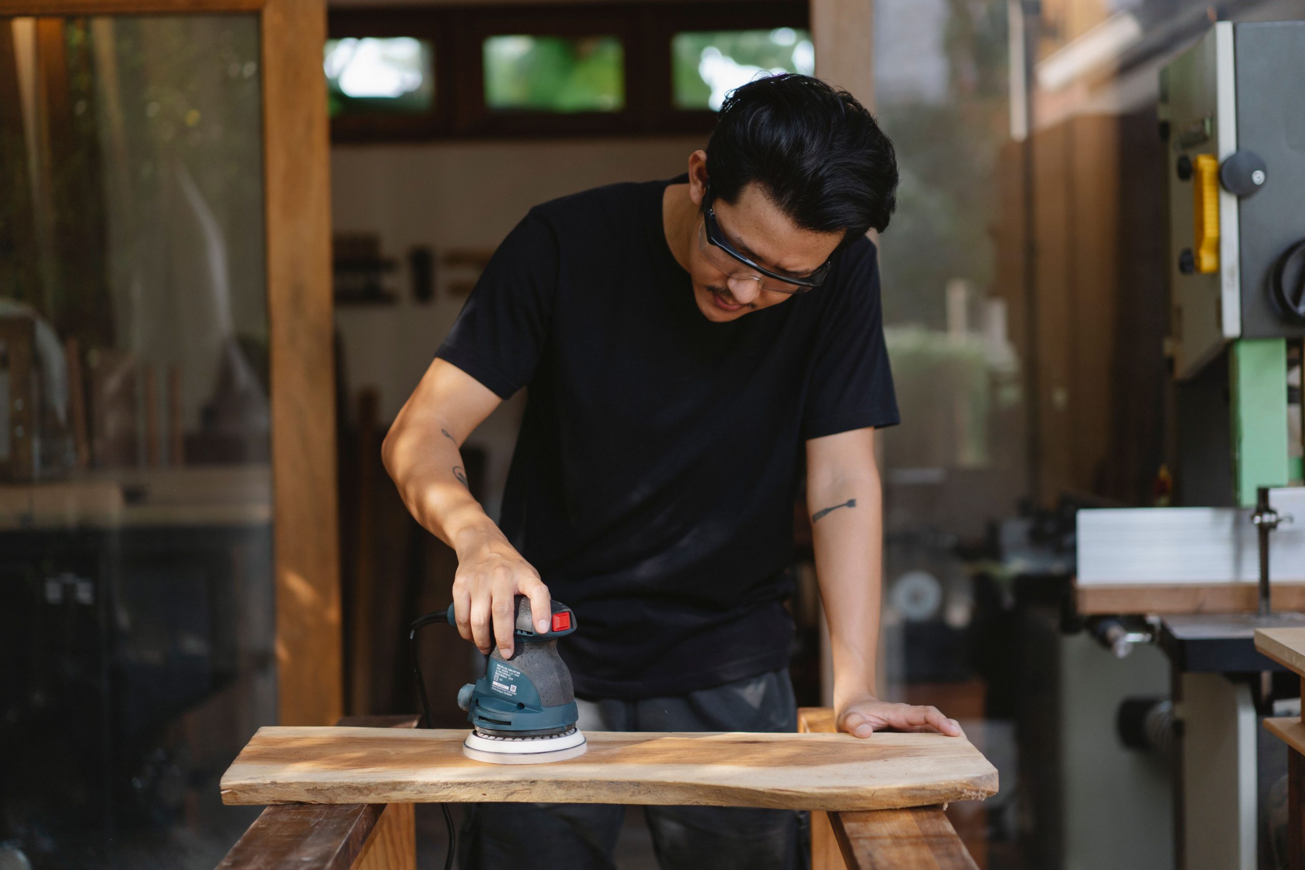 Artisan ponceur polissant planche bois avec soin