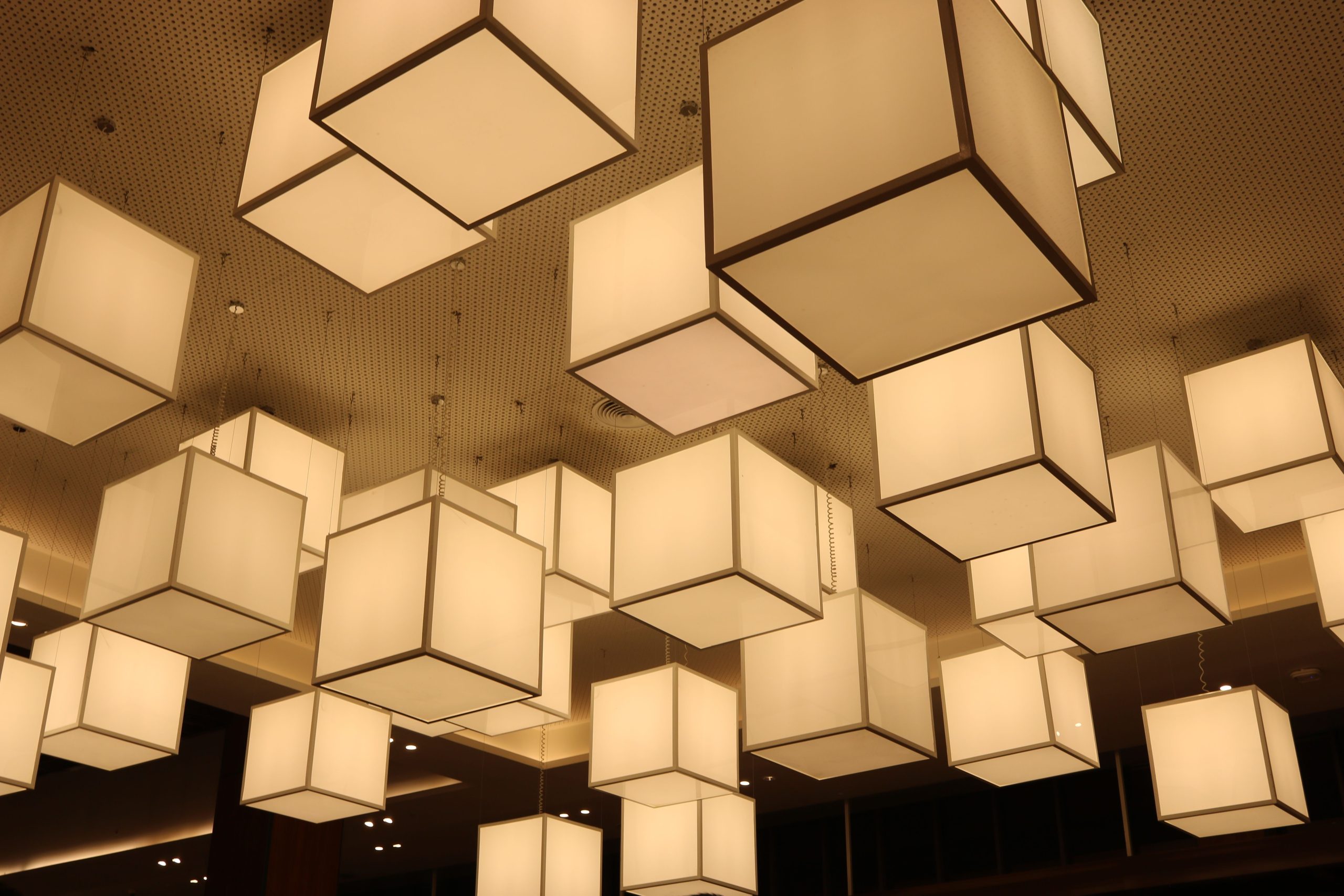Lampes de plafond géométriques illuminées dans un intérieur moderne